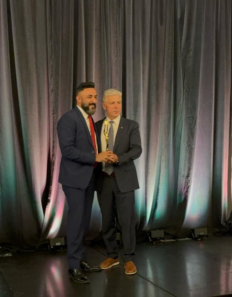 Jasjeet Singh receiving a Century 21 production award on stage in February 2024