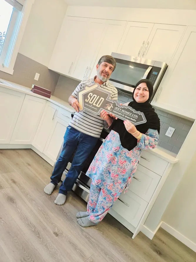 Clients with a sold sign in their new kitchen